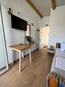 a room with a desk and a tv on the wall at Estia Rooms in Olympiada