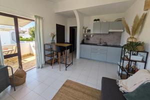 a kitchen and a living room with a table at Vivenda Josil - private pool 1km to beach & centre in Lagos