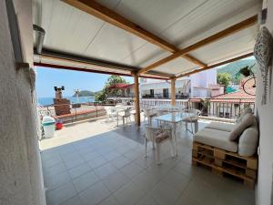 a patio with a table and chairs and a view of the ocean at Estia Rooms in Olympiada