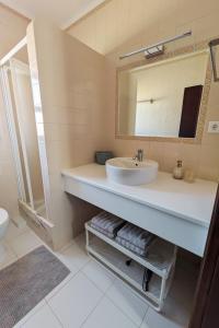 a bathroom with a sink and a mirror at Vivenda Josil - private pool 1km to beach & centre in Lagos