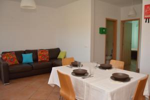 a dining room with a table and a couch at Monte da Fome Aguda in Odeceixe