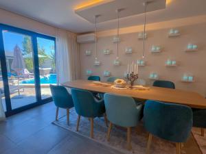 a dining room with a wooden table and blue chairs at Pino - Villa, Casa, Cucina е Terrazza in Albena