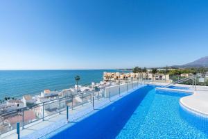 a swimming pool with a view of the ocean at Hello Cosmo in Estepona