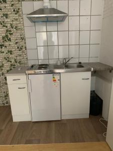 a small kitchen with a sink and a refrigerator at HD Rooms in Bremen