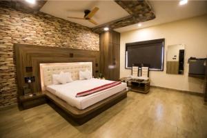 a bedroom with a large bed and a flat screen tv at TheJewelHotel in Hisār