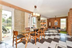 Un comedor y una sala de estar con mesa y sillas. en Scandi inspired holiday home Brentwood, en Brentwood