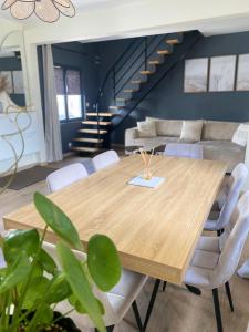 a dining room with a wooden table and white chairs at Maison jacuzzi privé - séjour détente 7personnes in Étaples