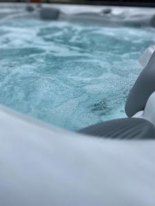 a person holding a cell phone in a swimming pool at Maison jacuzzi privé - séjour détente 7personnes in Étaples