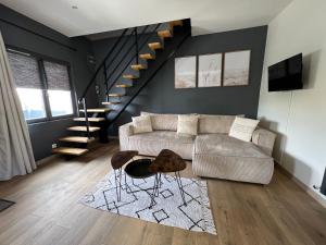 a living room with a couch and a staircase at Maison jacuzzi privé - séjour détente 7personnes in Étaples