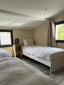 two beds in a room with two windows at Maison jacuzzi privé - séjour détente 7personnes in Étaples +41 photos