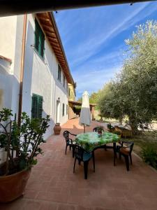 a patio with a table and chairs and an umbrella at Casa vacanze Eny in Capannori