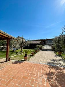 a brick driveway with potted plants in a yard at Casa vacanze Eny in Capannori