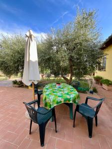 a table and chairs and an umbrella on a patio at Casa vacanze Eny in Capannori +50 photos