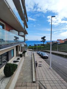 a building with cars parked on the side of a street at Un rincón con vistas a la Ría, playa y parking. in Ribeira