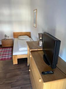 a small bedroom with a bed and a television on a dresser at Erlangen - 1 Zimmer Wohnung in Erlangen