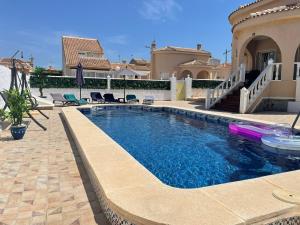 a swimming pool in front of a house at Villa Veranos, Rojales, Benijofar, Alicante, Valencia in Rojales