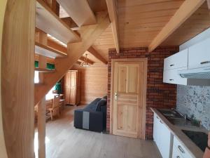 eine Küche und ein Wohnzimmer mit einem blauen Sofa in der Unterkunft Domki Harenda in Zakopane