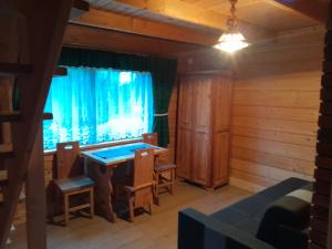 ein Raum mit einem Tisch und Stühlen und einem Fenster in der Unterkunft Domki Harenda in Zakopane