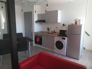 a kitchen with a washer and dryer in a room at F1 en duplex coquelicot in Lamalou-les-Bains