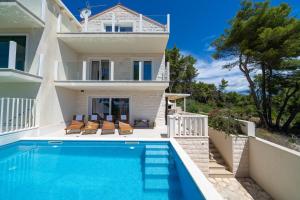 a villa with a swimming pool in front of a house at Villa Bruna in Sumartin