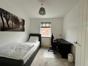 a bedroom with a bed and a desk and a computer at Merit Luxury Homes in Manchester