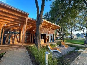 a wooden building with benches in front of it at Apartament G13 Nautica Resort Giżycko in Giżycko