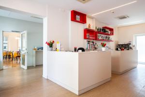 a white kitchen with red cabinets and a counter at Hotel Amicizia in Rimini