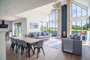 a dining room and living room with a table and chairs at Lowwood Lodges in Houston