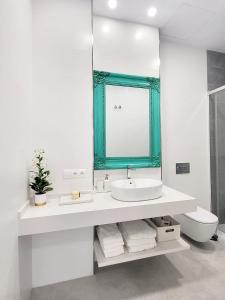 a bathroom with a sink and a mirror and a toilet at Apartamento Infantas 26 in Sanlúcar de Barrameda