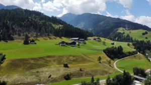 a golf course in the mountains with houses on a hill at Alpakahof Strieder in Maria Luggau +33 photos