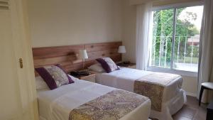 2 camas en una habitación de hotel con ventana en Joan Miró Hotel, en Punta del Este