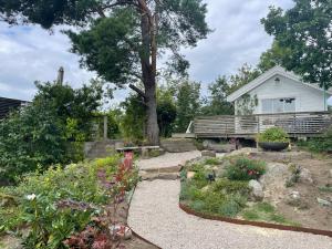 a garden with flowers and a white house at Nydelig fritidsbolig med sjøutsikt in Arendal