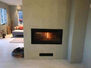 a fireplace in a living room with a fire in it at Nydelig fritidsbolig med sjøutsikt in Arendal