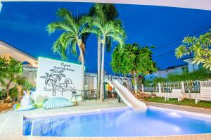 una piscina resort con tobogán y palmeras en Pupae Pool Villa Jomtien Pattaya, en Jomtien Beach
