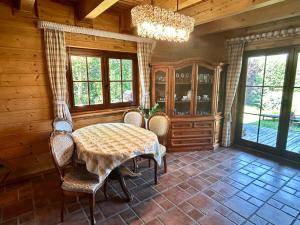 a dining room with a table and chairs and a chandelier at Villa Easy Living in Bierzwnik