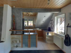 a kitchen with a counter and a sink and a guitar at Ferienwohnung Haus Peterstal in Trulben
