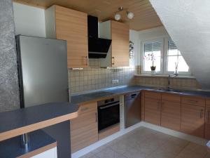 a kitchen with wooden cabinets and stainless steel appliances at Ferienwohnung Haus Peterstal in Trulben
