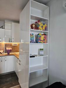 a white kitchen with white cabinets and shelves at Lake House - Bucuresti in Bucharest