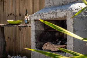 a stone fireplace with a green bowl and a bottle at Spectacular Ocean View at Ruby Bay in Mapua