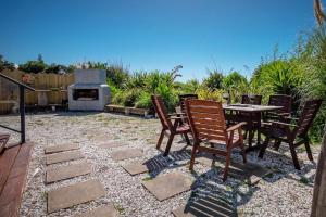 a patio with a table and chairs and a fireplace at Spectacular Ocean View at Ruby Bay in Mapua