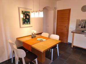 Un comedor con una mesa de madera y sillas blancas. en Haus Pichler Apartment, en Collalbo