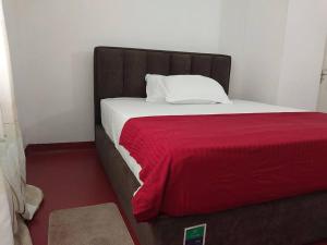 une chambre avec un lit avec une couverture rouge dans l'établissement The Birds Rest, à Sri Jayewardenepura Kotte