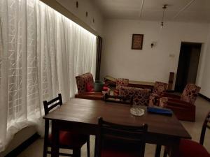 un salon avec une table et des chaises en bois dans l'établissement The Birds Rest, à Sri Jayewardenepura Kotte