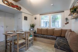 ein Wohnzimmer mit Sofa und Tisch in der Unterkunft Bungalow convivial à Saint-Jean-de-Monts avec piscine partagée in Saint-Jean-de-Monts