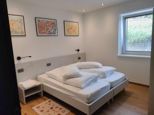 a bedroom with a bed with white walls and a window at appartamento PANORAMA in Pozza di Fassa