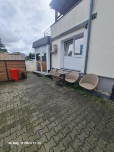 eine Terrasse mit 2 Stühlen und einem Picknicktisch neben einem Gebäude in der Unterkunft Handwerkerwohnung-Monteurunterkunft in Darmstadt