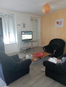 un salon avec deux chaises et une télévision dans l'établissement Saint Pair sur Mer 50 m de la plage, à Saint-Pair-sur-Mer