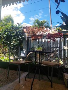 a patio with a table and benches with plants at Kaz MADO - Meublé de tourisme classé 3 étoiles in Le Tampon