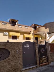 a building with a black door and a fence at Mazzeo in Santa Maria di Castellabate