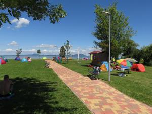 a park with tents and people sitting on the grass at Villa Balcsi in Balatonmáriafürdő